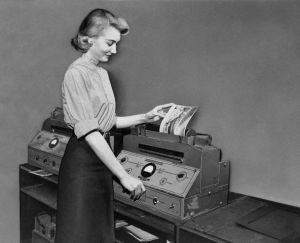 1956, New York, New York, USA --- How United Press sends newspictures: 12:30 P.M. - Within 15 minutes, a print is ready to send over the coast-to-coast United Press Telephoto wire network and an operator slips it into the Trans-ceiver machine for transmission. --- Image by © Bettmann/CORBIS