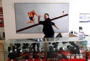 Photographer Darrin Zammit Lupi posing next to his photo at Avantech offices, February 24, 2014