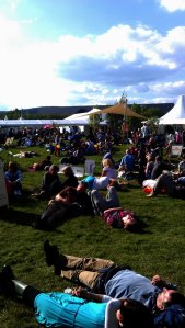 Public is sunbathing  in the lounge area in front of  the festival's bookstore