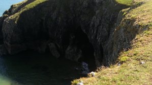 There are small caves in the cliffs, but you cannot get there from the top - you will have to hire a rowing boat