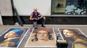 Street artist Richard Price inspects his paintings on High Street, Worcester